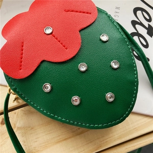 Close-up of strawberry-shaped green crossbody bag with sparkling rhinestone accents