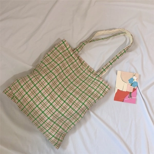 Green and pink checkered canvas tote bag with long straps in a stylish 45-degree view