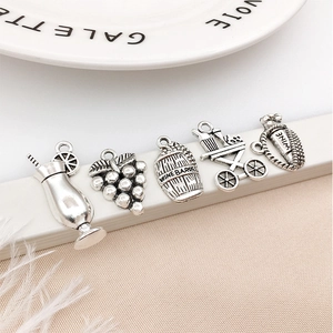 Makroaufnahme von antiken silbernen Wein-Anhängern für DIY-Schmuck mit Fässern und Trauben