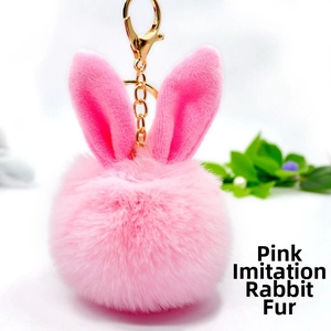Detailed view of pink faux rabbit fur keychain with cute bunny ears and gold metal clasp