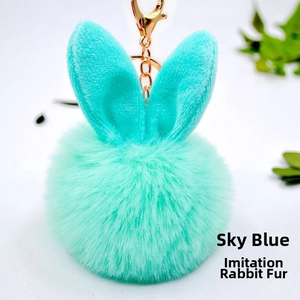 Detail of light mint blue faux rabbit fur pompom keychain with cute bunny ears