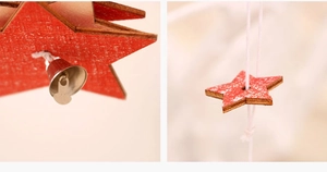 Detail of red wooden star ornament with small silver metal bell and hanging string