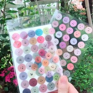 Handheld geometric smile and circle washi stickers in soft pastel colors for journals