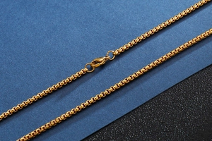 Detail of gold beaded chain necklace with secure lobster clasp and metallic finish