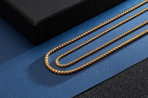 Detailed close-up of a polished gold-plated stainless steel box chain for men