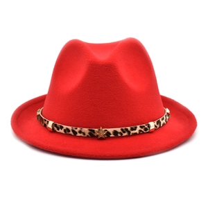 Detail view of red wide brim fedora hat featuring a leopard print band and gold star studs