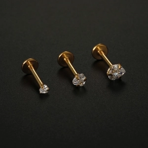 Three gold titanium steel labret studs with cubic zirconia in different sizes