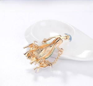 Detail of elegant woman silhouette brooch back with secure pin and gold chain link