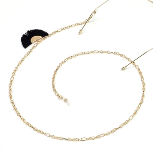Detailed shot of golden metal eyewear chain with a black fan-shaped tassel charm