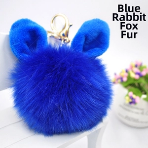 Close-up of blue plush rabbit ear fur ball keychain with golden metal hook detail
