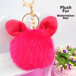 Detailed view of watermelon red plush ball keychain with rabbit ears and golden clasp