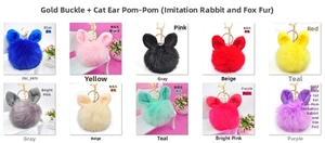 Macro shot of colorful plush pompom keychains with cute rabbit ears and gold clasps