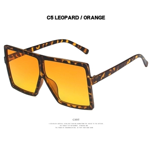 Detail view of oversized square leopard print sunglasses with orange tinted lenses