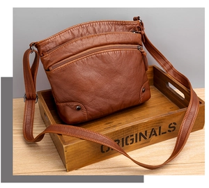 Détail d'un sac bandoulière en cuir PU marron avec rivets métalliques et bandoulière