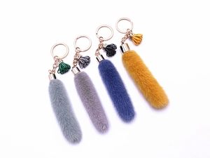 Detail of colorful plush tail keychains with gold rings and matching tassels
