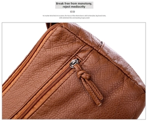 Close-up of brown litchi texture leather crossbody bag featuring metal zipper details