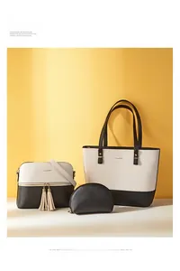 Detailed close-up of 3-in-1 tote bag set with golden hardware and tassel in cream and black