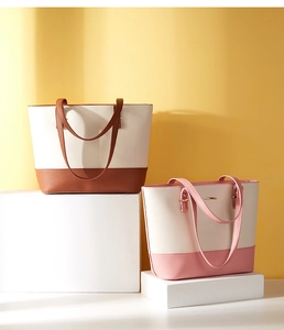 Detailed view of two-tone PU leather tote bags in brown and pink on display stands