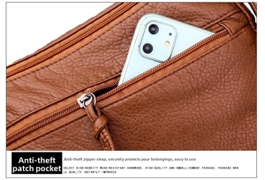 Detail of caramel brown leather shoulder bag featuring a rear anti-theft pocket for a phone