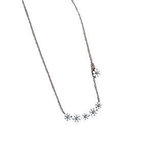 Minimalist titanium steel necklace with five white floral charms on a gold chain