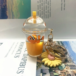Macro view of a creative liquid acrylic milk tea cup keychain with a small clownfish charm