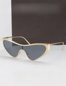 Detail of futuristic triangle cat-eye sunglasses with gold metal frame and dark gray lens