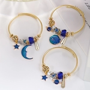 Gold stainless steel celestial bangle set with blue star and moon mosaic charms