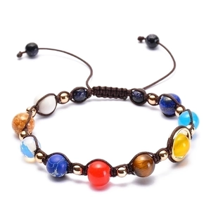 Detailed view of solar system planet beads on an adjustable brown braided nylon rope bracelet
