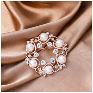 Elegant rose gold flower wreath brooch with white pearls and sparkling zircons on satin