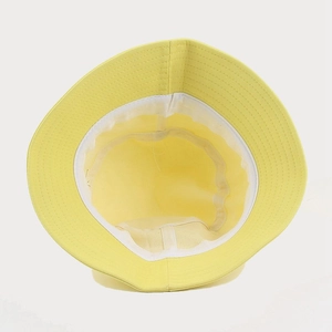 Close-up of yellow bucket hat interior showing white inner lining and premium stitching