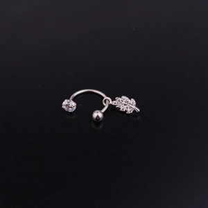 Close-up of curved steel barbell piercing with sparkling leaf pendant and CZ stones