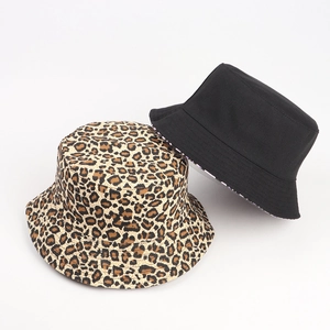 Flat lay of reversible leopard print and solid black bucket hats in soft canvas material
