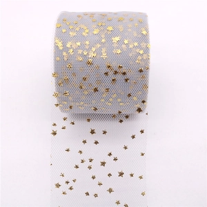 Detail of grey tulle fabric roll with gold foil star patterns for DIY hair accessories