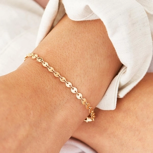 Minimalist gold plated stainless steel disc chain bracelet worn on a female wrist