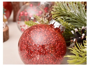 Close-up of red sequined Christmas ball ornament with silver cap and pine cone background