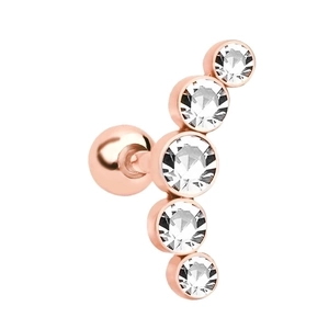 Macro detail of rose gold cartilage piercing with five graduated sparkling crystals