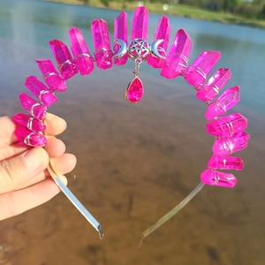 Detail of pink crystal crown featuring a silver crescent moon and pentagram pendant