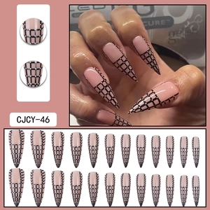 Macro detail of long stiletto press-on nails with nude base and black-white grid pattern