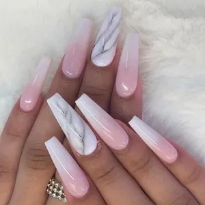 Macro view of long coffin nails with soft pink ombre and white marble patterns