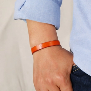 Orange adjustable leather bracelet for men shown on wrist in a minimalist style