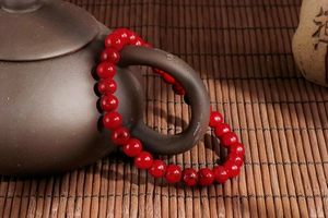 Detail of red turquoise beaded bracelet hanging on a traditional teapot handle