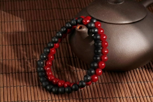 Close-up of retro turquoise and agate beaded bracelets on a traditional teapot
