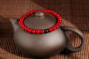 Macro detail of vintage red turquoise beaded bracelet with black matte bead on teapot