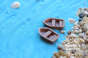 Miniature resin boat models with wood grain texture in a moss micro landscape scene