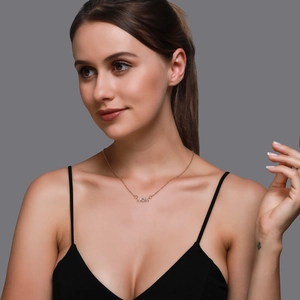 Détail du collier MOM en or rose avec incrustation de zircon sur un mannequin