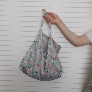Close-up of floral cotton tote bag with white daisies and knotted handle design