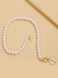 Close-up of vintage multi-layer pearl necklace with a gold coin pendant and OT clasp