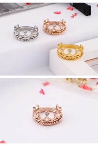 Detailaufnahme kronenförmiger Ringe mit Zirkoniasteinen in drei verschiedenen Metallfarben