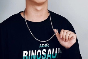 Close-up of a silver stainless steel box chain necklace worn by a male model