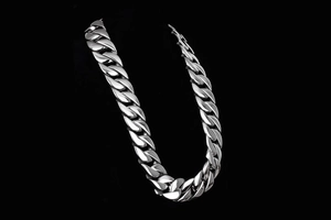 Detail view of heavy silver stainless steel Cuban link necklace for men on black background